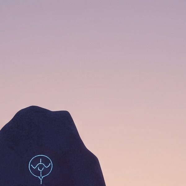 A photorealistic 3D render of a minimalist American landscape at dusk, featuring a weathered stone monolith with glowing ancient symbols and circuits, juxtaposed against modern wind turbines under a pastel gradient sky.